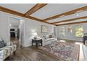 Bright and airy living room featuring hardwood floors, beamed ceilings, and natural light at 7517 Chippenham Ct, Raleigh, NC 27613
