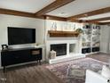Bright and inviting living room with a fireplace, built-in shelving and dark wood floors at 7517 Chippenham Ct, Raleigh, NC 27613