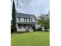 Traditional two-story home with a welcoming front porch, mature landscaping, and classic curb appeal at 7621 Troy Stone Dr, Fuquay Varina, NC 27526