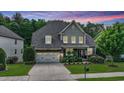 Charming two-story home with a well-manicured lawn, stone accents, and an attached two-car garage at 82 Idlewood Ln, Clayton, NC 27527
