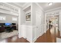 Inviting hallway with wainscoting and wood floors leading to a home office at 821 Laurel Garden Way, Cary, NC 27513