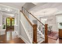 Elegant staircase with wood and white accents leads to a formal dining room at 821 Laurel Garden Way, Cary, NC 27513