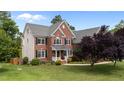 A charming brick home featuring a well-maintained lawn and lovely landscaping at 1004 Taywood Way, Apex, NC 27502