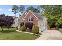 Well-maintained brick home featuring a pristine lawn and professional landscaping at 1004 Taywood Way, Apex, NC 27502