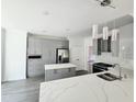 Modern kitchen with sleek gray cabinets, stainless steel appliances, and a large island with a quartz countertop at 1039 Bellenden Dr, Durham, NC 27713