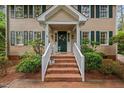 Inviting front entrance with brick steps, white railings, and a welcoming floral wreath on the door at 108 Farren Ct, Cary, NC 27511