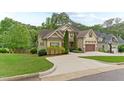 Exterior shot from the side angle of this home showcasing the driveway, lawn and manicured bushes and trees at 1101 Temple St, Raleigh, NC 27609