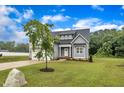 A beautiful two-story gray home with well-maintained landscaping and a lush green lawn at 1109 Agio Ct, Zebulon, NC 27597