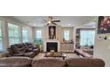 Comfortable living room featuring a fireplace, plush seating, and a decorative ceiling fan at 1116 Trotter Bluffs Dr, Holly Springs, NC 27540