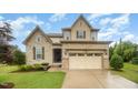 Beautiful home with stone and siding exterior, an arched entryway, and a manicured front lawn at 1201 Pleasant Falls Ct, Wake Forest, NC 27587