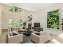 Bright living room with high ceilings, fireplace, and large windows offering serene views at 122 N Fern Abbey Ln, Cary, NC 27518
