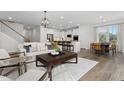 Open-concept living room with wood floors, neutral furniture, and lots of natural light at 135 Harmony Ranch Lane, Franklinton, NC 27525