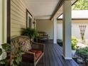 Relaxing covered front porch featuring comfortable wicker seating and views of the serene surroundings at 1514 John Jones Rd, Bahama, NC 27503