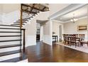 Grand foyer with hardwood flooring, a staircase with dark wood accents, and an adjacent formal dining room at 1540 Sandybrook Ln, Wake Forest, NC 27587