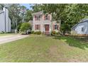 Charming two-story home with cream siding, red shutters, a white railed porch, and a well-manicured lawn at 1605 Hall Blvd, Garner, NC 27529