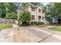 Charming two-story home with cream siding, red shutters, a white railed porch, and a concrete driveway at 1605 Hall Blvd, Garner, NC 27529