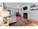 Cozy living room featuring a fireplace with mantle, hardwood floors, ceiling fan, and comfortable seating at 1605 Hall Blvd, Garner, NC 27529
