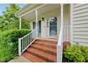 Inviting front porch with brick steps and white railings offering a cozy entrance at 1605 Old London Way, Apex, NC 27523