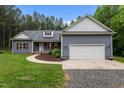 Charming one story home featuring a two-car garage, landscaped front yard, and inviting curb appeal at 1850 Willie Pace Rd, Burlington, NC 27217