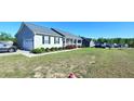 Inviting home featuring a covered porch, attached garage, and a beautifully landscaped front yard at 212 Placid Pond Dr, Broadway, NC 27505