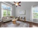 Bright, airy living room with large windows, ceiling fan, neutral decor and hardwood floors at 2316 Apex Peakway, Apex, NC 27502