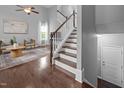 Bright living room with hardwood floors, vaulted ceiling, elegant staircase and natural light at 2316 Apex Peakway, Apex, NC 27502