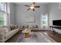 Spacious living room with hardwood floors, ceiling fan, modern decor, and natural light at 2316 Apex Peakway, Apex, NC 27502
