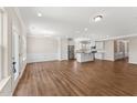 Spacious living room adjacent to the kitchen features stylish wood flooring and a bright, open floor plan at 233 Theys Mill Way, Fuquay Varina, NC 27526