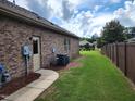 Side view of home showcasing utilities, sidewalk, and fenced in backyard at 243 Nortwick Rd, Rolesville, NC 27571