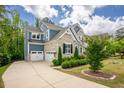 Side view of home with blue siding, stone accents, a well-kept lawn and a two car garage at 2737 Willow Rock Ln, Apex, NC 27523