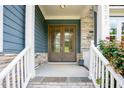 Close-up of a home's double front doors, complemented by stone accents and manicured shrubs at 2737 Willow Rock Ln, Apex, NC 27523