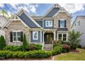 Charming two-story home with stone and blue siding, manicured landscaping, and a welcoming entrance at 2737 Willow Rock Ln, Apex, NC 27523