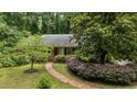 Beautifully landscaped property featuring a one-story home with a red front door and a brick pathway leading to the entrance at 3125 Stanford Dr, Durham, NC 27707