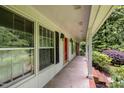 Covered porch view showcasing the red front door, adjacent windows, and a well-maintained exterior at 3125 Stanford Dr, Durham, NC 27707