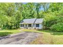 Attractive single-story home with a well-kept lawn, mature trees, and a paved driveway leading to the property at 324 Waterside Dr, Sanford, NC 27330