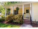 Inviting front porch with hanging ferns and classic white columns at 3359 Denise St, Durham, NC 27704