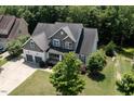 Aerial view of a well-maintained home showcasing its landscaped yard, two-car garage, and serene surroundings at 337 Shadowdale Ln, Rolesville, NC 27571