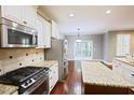 Well-lit kitchen featuring granite countertops, stainless steel appliances, and hardwood floors at 337 Shadowdale Ln, Rolesville, NC 27571
