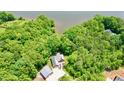 Aerial view of home featuring mature trees, a detached garage, and waterfront views at 3750 Mebane Rogers Rd, Mebane, NC 27302