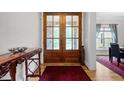 Grand entryway featuring hardwood floors, a decorative rug, and wood double doors with glass panels at 4306 Infinity Ln, Durham, NC 27705