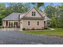 View of home with stone and siding, driveway, and landscaping at 4306 Infinity Ln, Durham, NC 27705