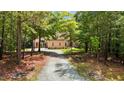 Long gravel driveway leading to a beautiful home surrounded by trees at 4306 Infinity Ln, Durham, NC 27705