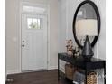 A lovely front entry with a black accent table, basket storage, and a charming mirror and entry door at 456 Golden Dragonfly St, Wake Forest, NC 27587