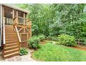 Backyard with a wooden deck overlooking a manicured lawn and a mature tree line at 6335 Cedar Waters Dr, Raleigh, NC 27607