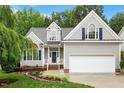 Charming home featuring a landscaped front yard, two-car garage, and a welcoming entrance at 6335 Cedar Waters Dr, Raleigh, NC 27607