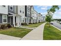 Street view of modern townhomes featuring well-kept lawns and sidewalks for community charm at 6352 Perry Creek Rd, Raleigh, NC 27616