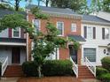 Inviting townhome exterior featuring brick facade and lush green landscaping at 6756 Olde Province Ct, Raleigh, NC 27609