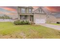Alluring two-story home showcasing a manicured lawn, welcoming front porch, and a convenient two-car garage at 71 Sandy Farm Ct, Willow Springs, NC 27592
