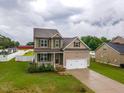 Inviting two-story home with a well-kept lawn, cozy front porch, and an attached two-car garage at 71 Sandy Farm Ct, Willow Springs, NC 27592
