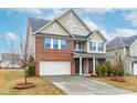 Attractive two-story house with brick, vinyl siding, attached garage, and beautifully landscaped front yard at 7584 Oakberry Dr, Raleigh, NC 27616
